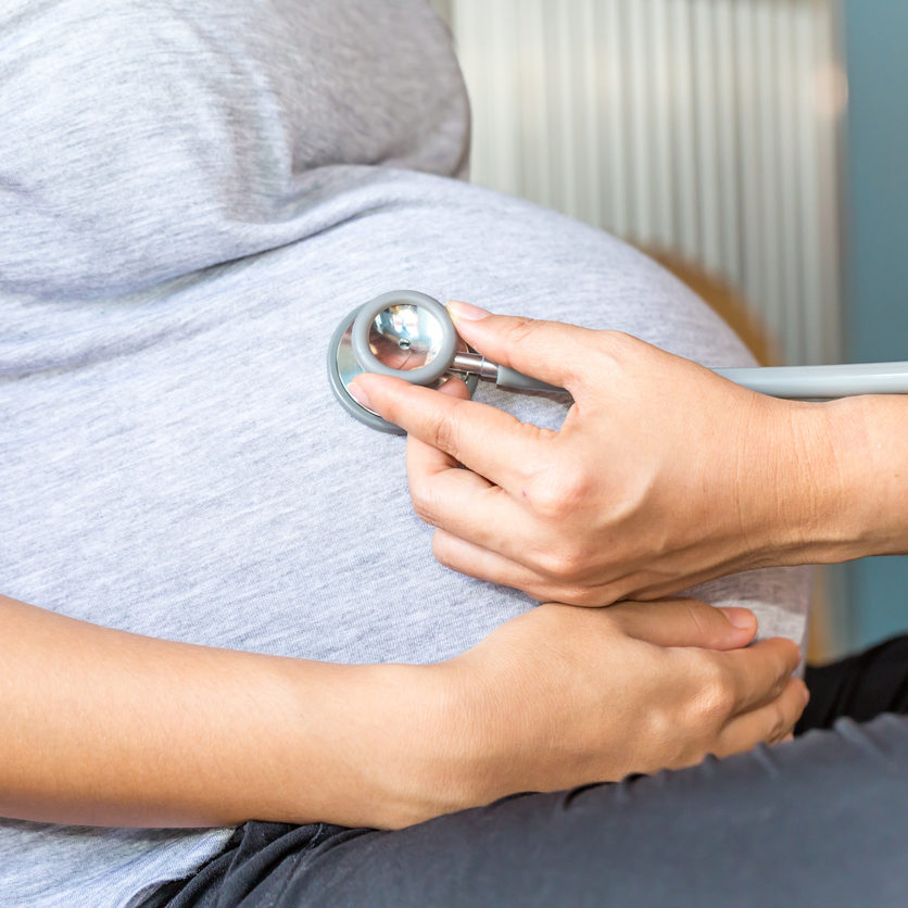 Hands of doctor examining a pregnant woman