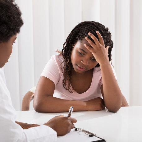 Portrait Of Female Doctor Comforting Depressed Patient